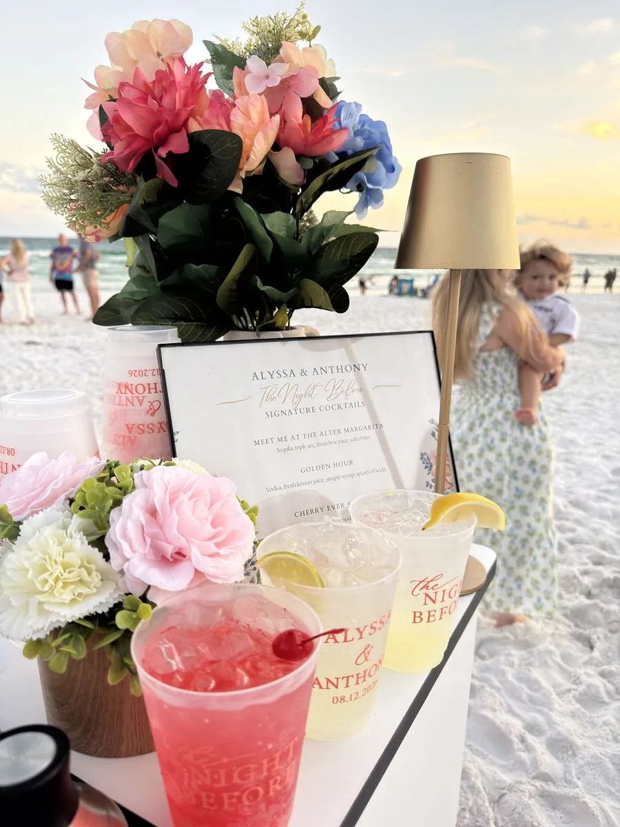 A Happy Pour beach bar with fresh flowers and pink signature cocktails at sunset