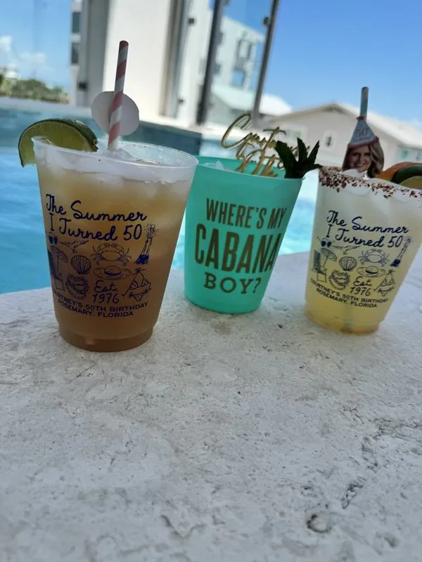 Cocktails in custom 50th birthday cups by the pool in Rosemary Beach
