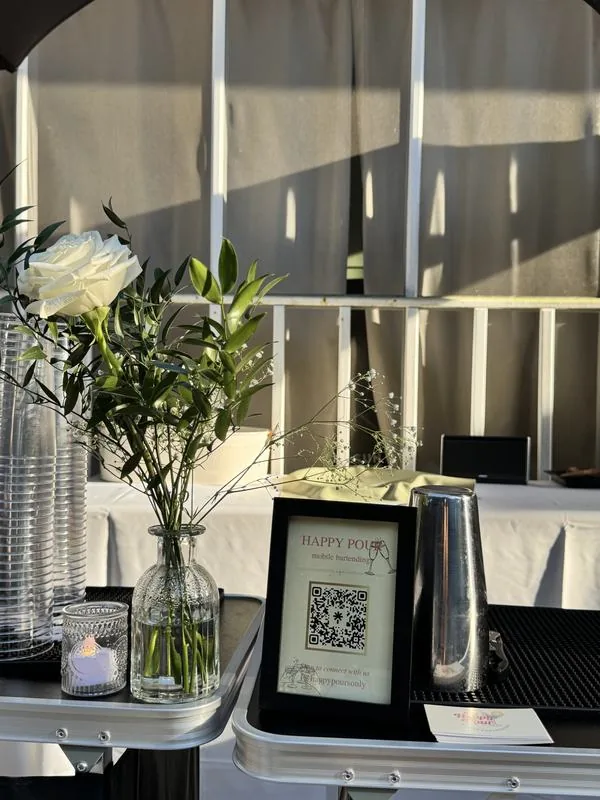 A white rose, candle and Happy Pour sign styled on the bar